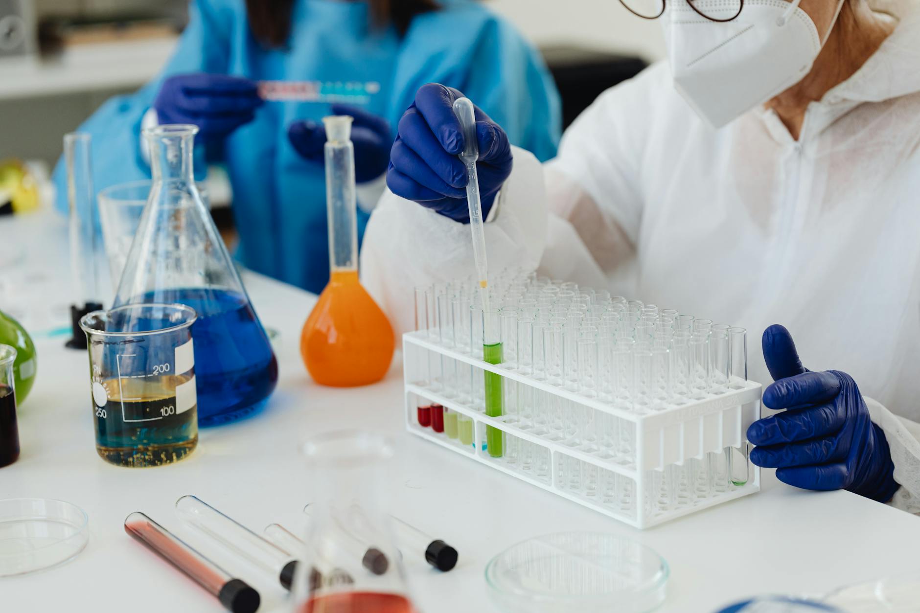 Laboratory scientists working with test tubes and liquids, performing chemical experiments.