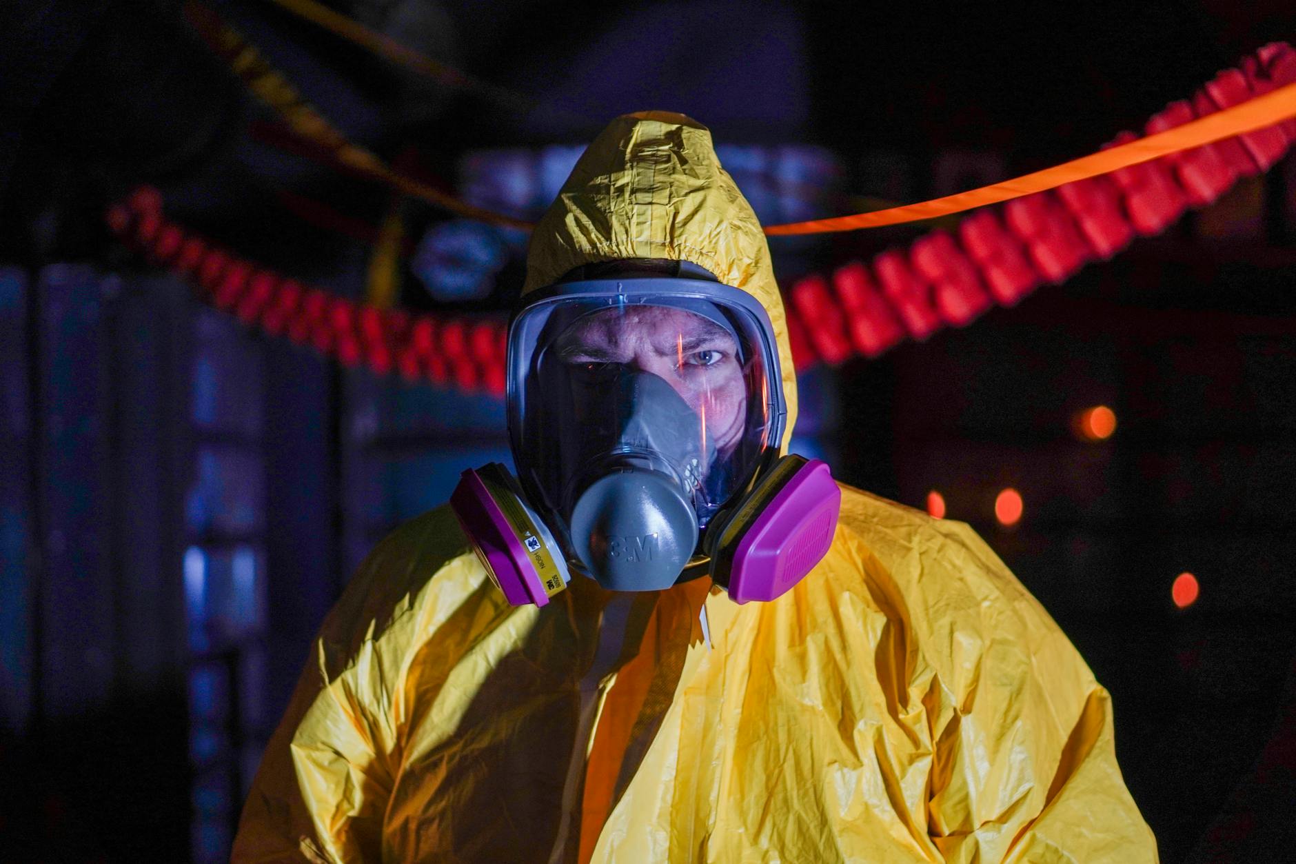 Person in hazmat suit and gas mask in an industrial setting, Kyiv, Ukraine.